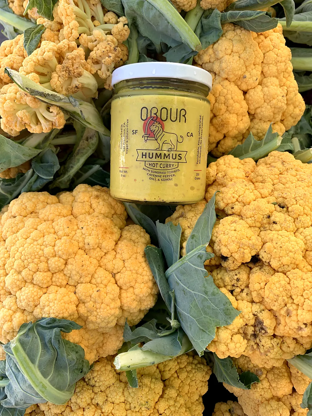 A jar of Hot Curry hummus among orange cauliflower