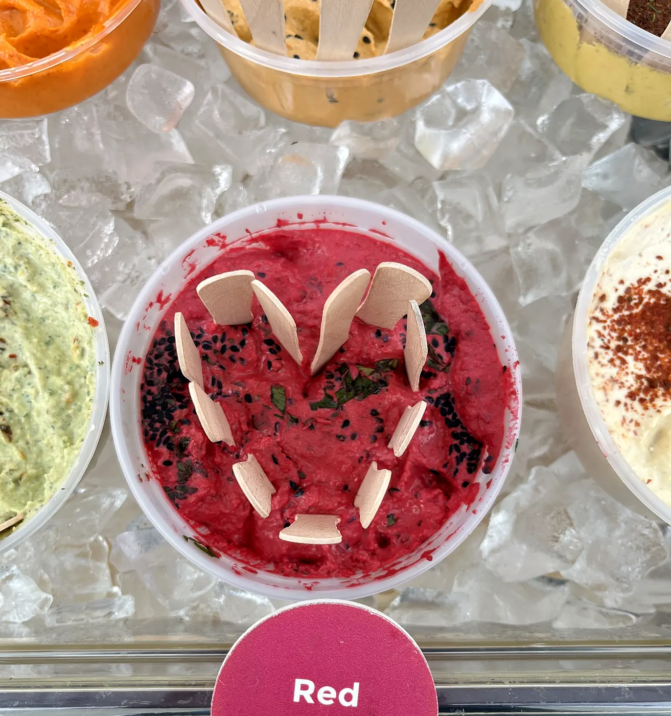 A tub of Red Beet hummus on ice, garnished with a heart