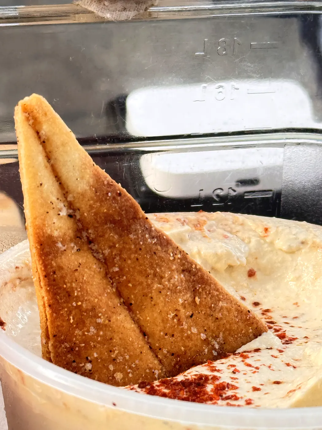 A pita chip dipped in Classic hummus
